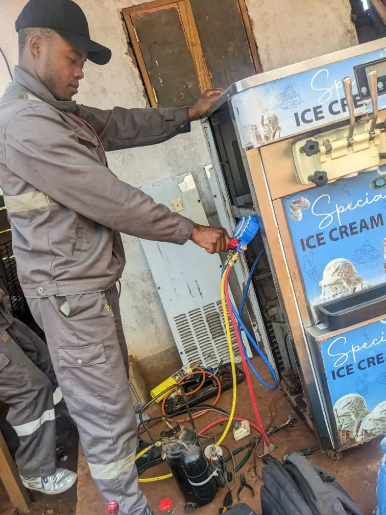 Technicien contrôlant les pressions d'une machine à crème glacée avec un manifold